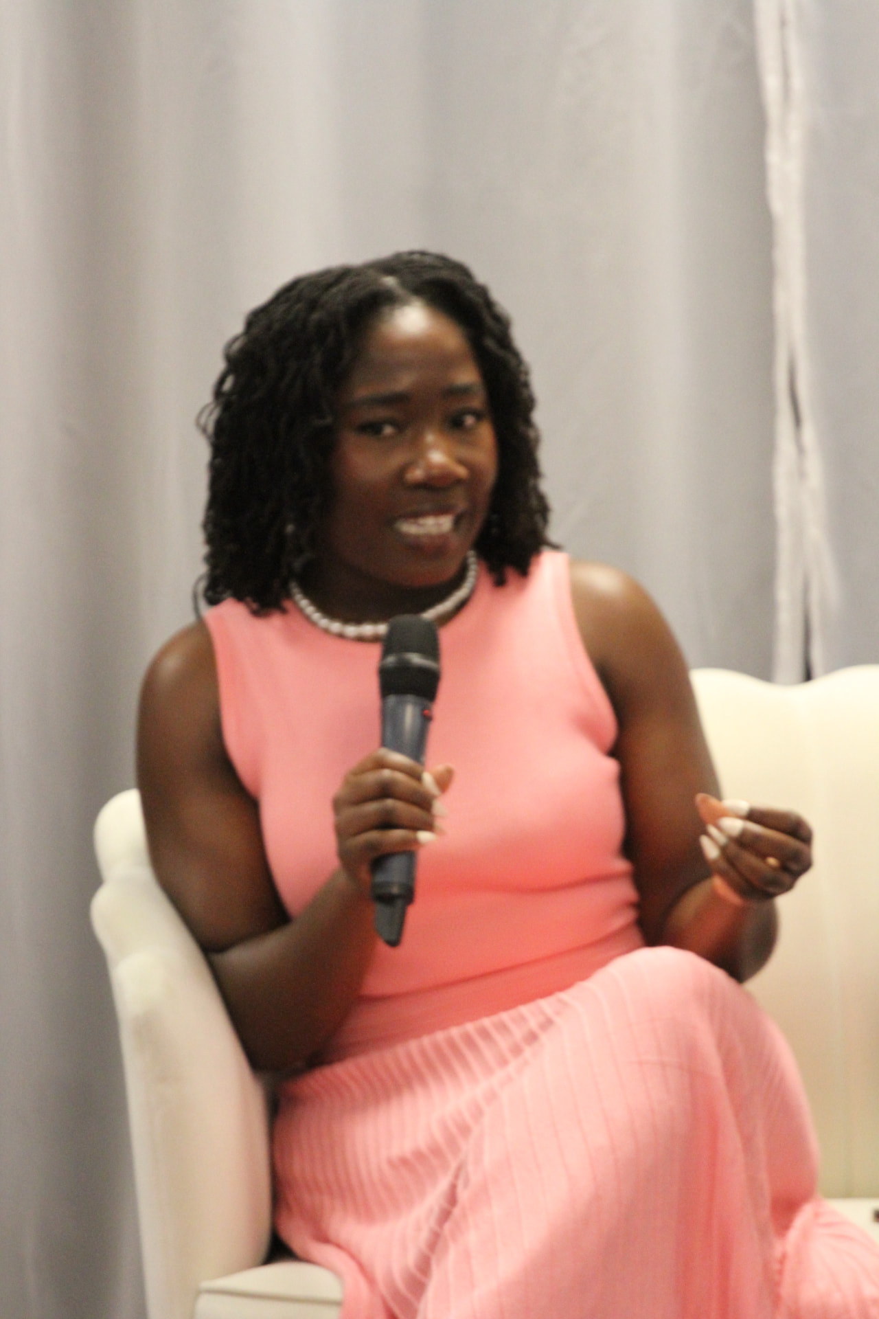 Panelist in pink sharing her story on stage